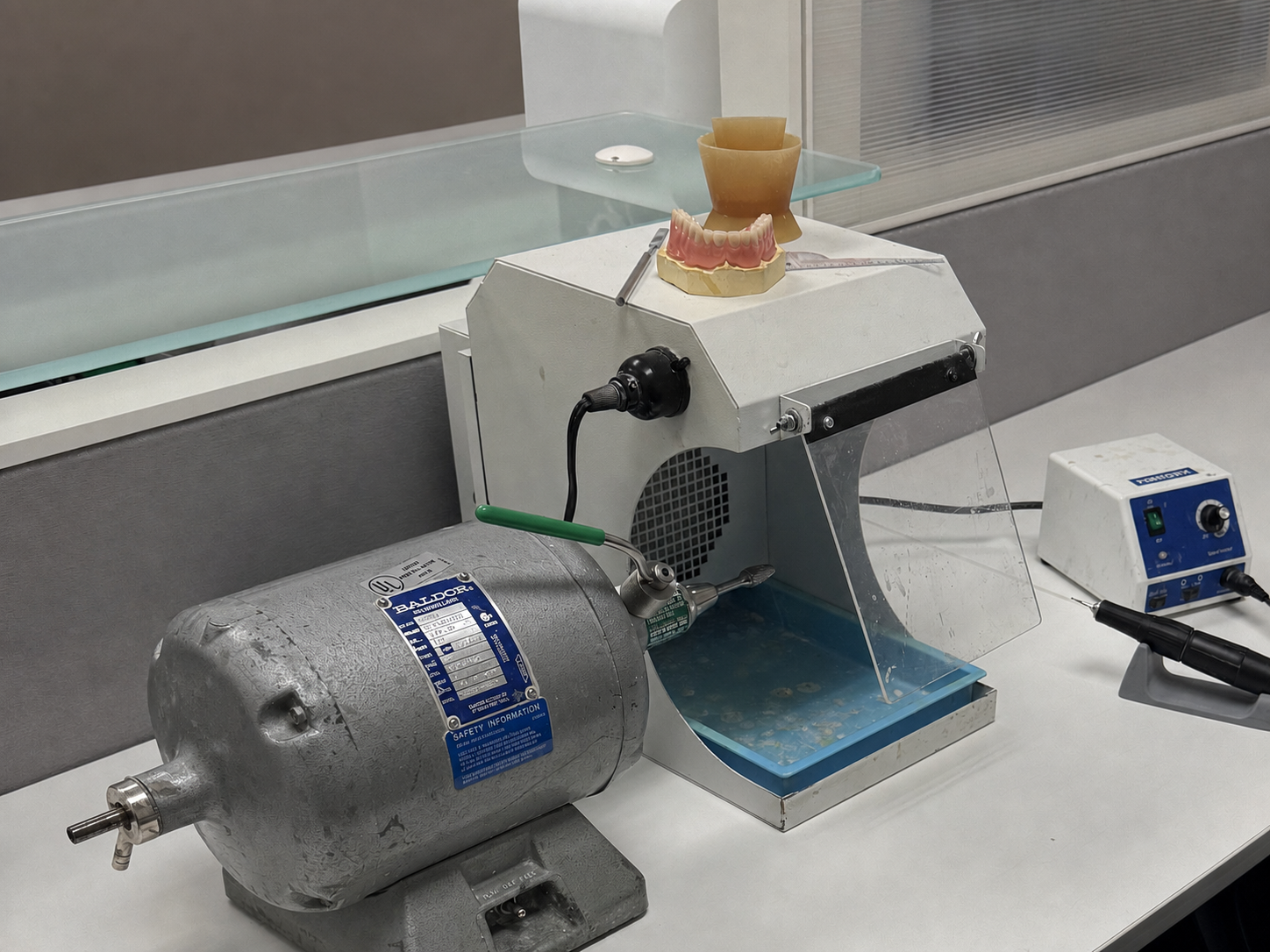 Broken Denture Repair laboratory workstation with polishing lathe, vacuum hood, handpiece, and denture materials